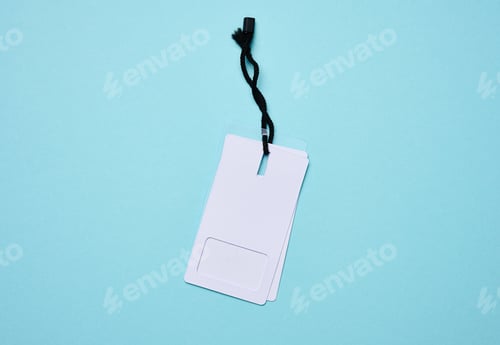 Preview: Blank rectangular paper white price tag with black rope on a blue background