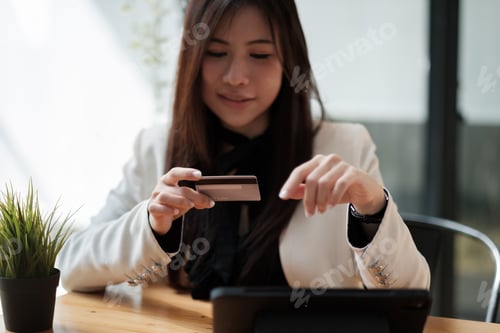 Preview: Young woman holding credit card and using smart phone for online shopping. Online payment shopping