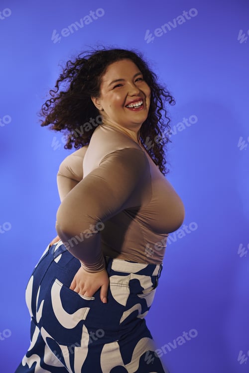 Preview: Embracing confidence and joy, a beautiful plus size woman poses playfully against a vibrant backdrop