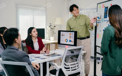 Preview: Asian business team discussing project strategy during office meeting
