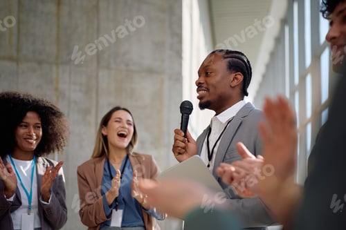 Preview: Black business seminar speaker receiving applause from his colleagues.