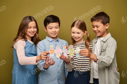 Preview: Smiling interracial preteen kids in casual clothes with friends holding drawn paper characters while