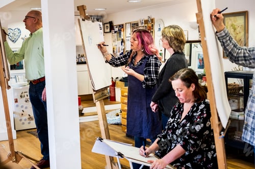 Preview: Group of artists standing and sitting at easels, drawing.