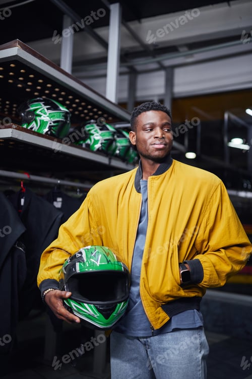 Preview: Young Adult Man Holding a Racing Helmet