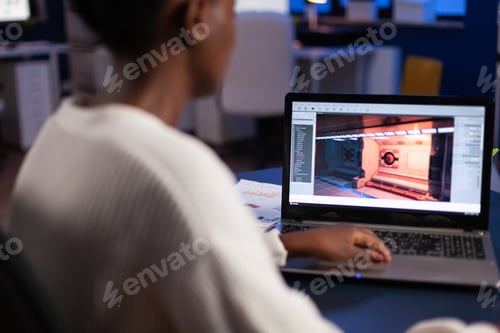 Preview: African american game developer testing new game working late at night