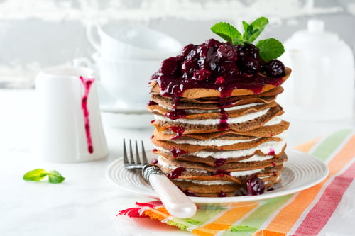 Preview: Pancake chocolate cake with cottage cheese filling and cherry sauce on a light background. Selective