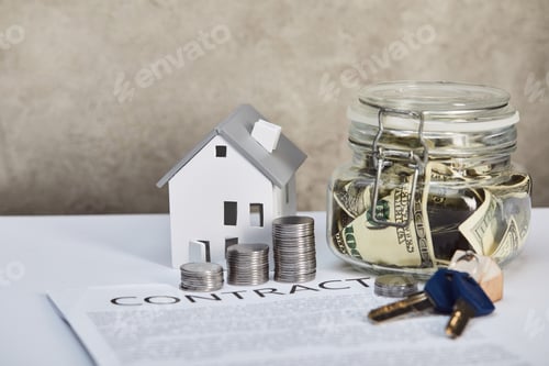 Preview: house model on white table with silver coins, keys, contract and moneybox on grey background, real