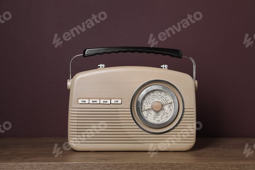Preview: Retro radio receiver on wooden table against brown background