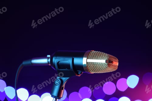 Preview: Microphone on stand against color background with blurred lights, space for text. Bokeh effect