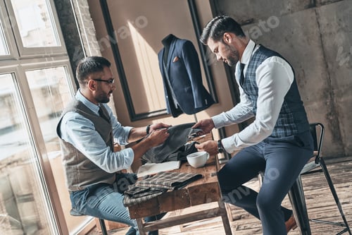 Preview: Men Discussing Fabric for Suit in Tailor Shop