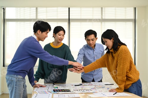 Preview: Startup businesspeople stacking hands together, celebrating completion of project.