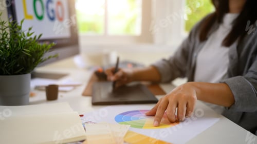 Preview: Cropped shot woman graphic designer creating logo on digital tablet