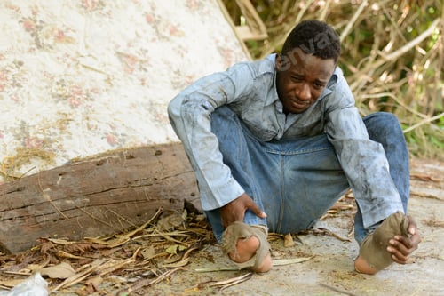 Preview: Sad young homeless African man crying in the streets