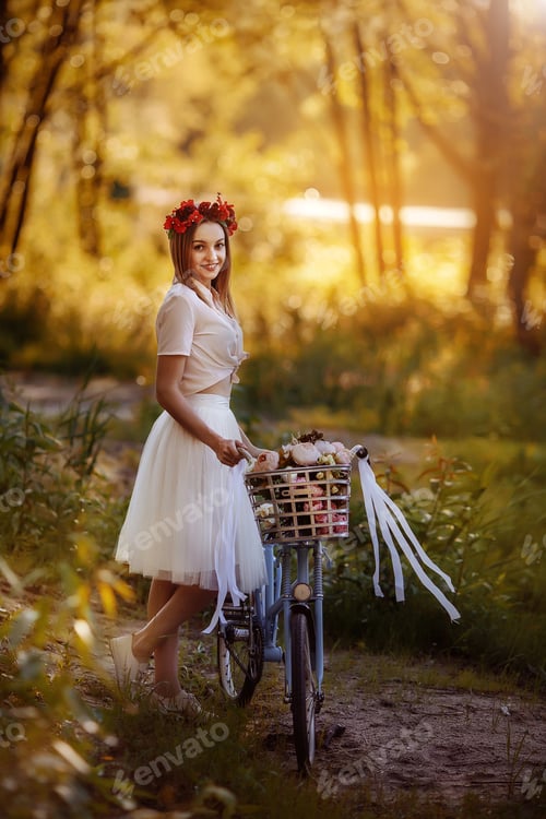 Preview: Girl in with a bike in the forest at sunset