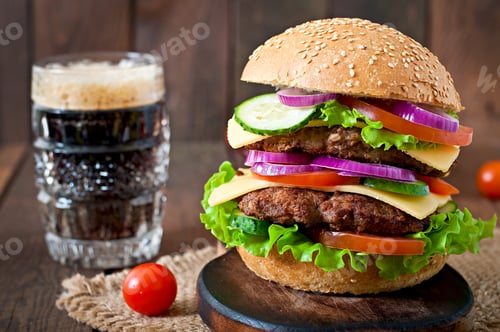 Preview: Big juicy hamburger with vegetables and beef on a wooden background in rustic style