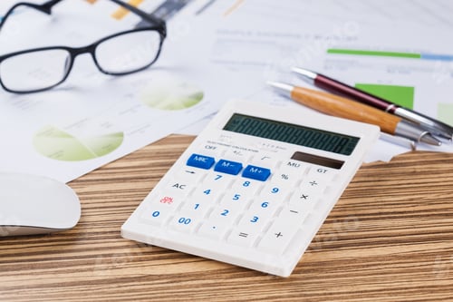 Preview: Desk scene with calculator, papers, glasses, and pens during work on financial plans