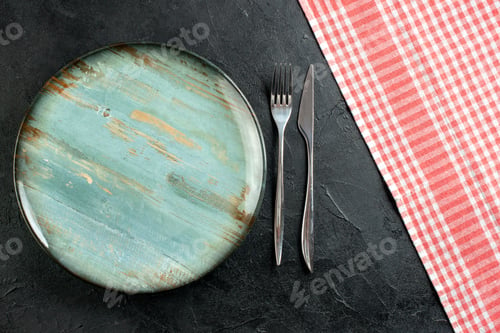 Preview: top view round platter fork and dinner knife red and white checkered tablecloth on black table