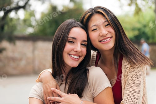 Preview: young female couple smiling and looking at camera