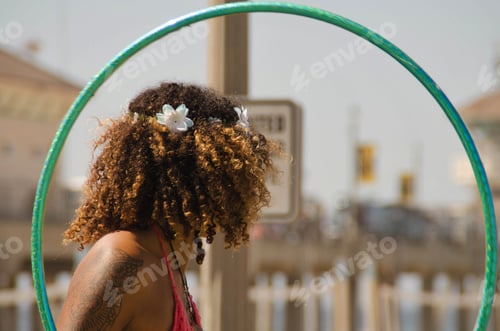 Preview: Shot from behind, African American black woman with a flower in her hair and a hula hoop
