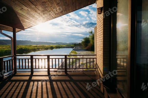 Preview: scenic view of beautiful sunset over river from wooden terrace