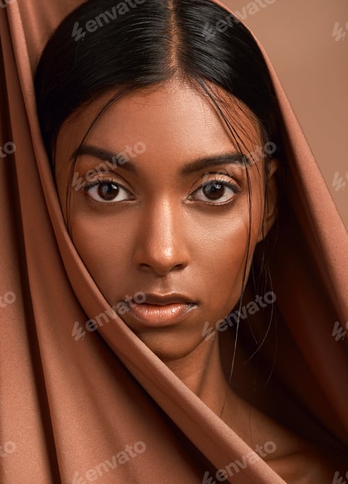 Preview: Portrait of an attractive young woman wearing a head scarf against a brown background