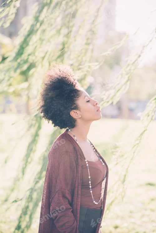 Preview: Young beautiful afro black woman outdoor in the city back light feeling free