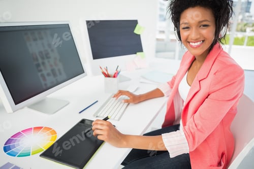 Preview: Portrait Of A Casual Female Photo Editor Using Computer In A Bright Office