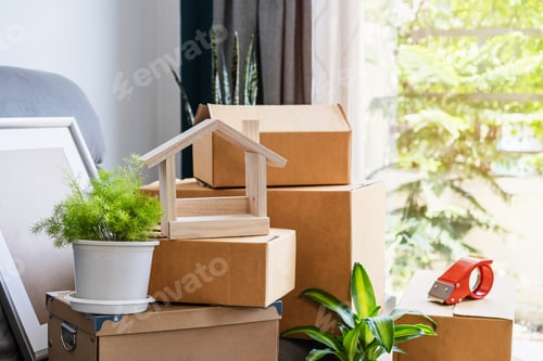 Preview: Stack of cardboard boxes in living room at new house on moving day