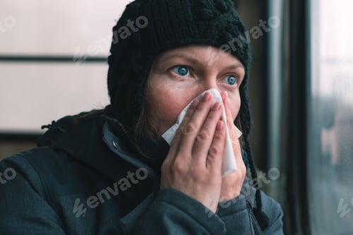 Preview: Woman blowing her nose into paper handkerchief