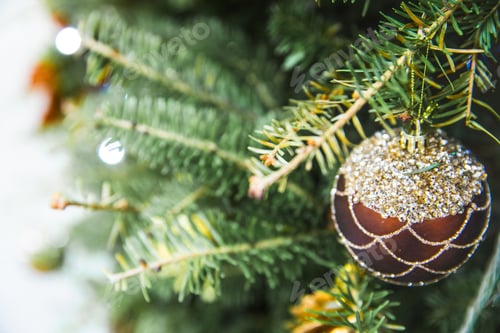 Preview: Close up of bauble hanging on the Christmas tree with other toys.