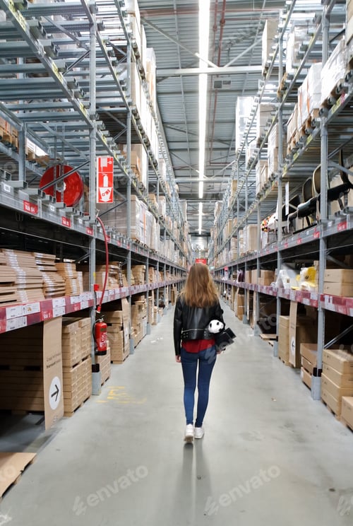 Preview: Girl walking in the storage area to collect her order. Vanishing point. Boxes.