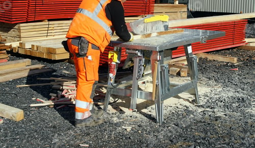 Preview: Worker sawing wood on a table saw