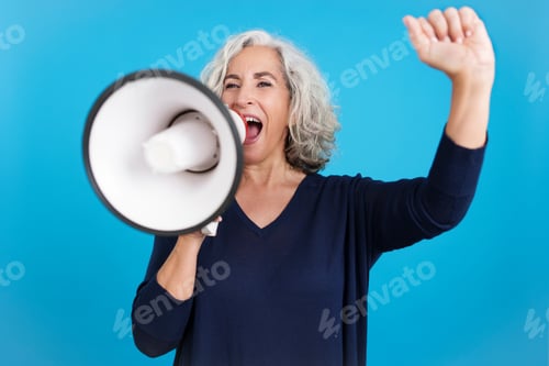 Preview: Mature woman raising the fist and protesting with a loudspeaker