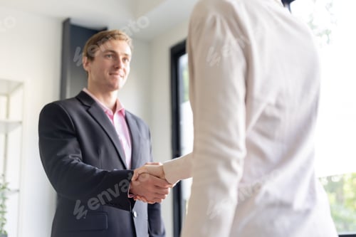 Preview: Businessman in black suit having a handshake in a modern office