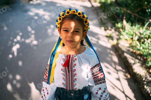Preview: Child girl in Ukrainian traditional clothes and flower wreath is praying outdoors in a sunlight