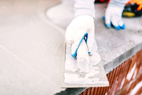 Preview: close-up of worker steel trowel and hand, using plastering tools