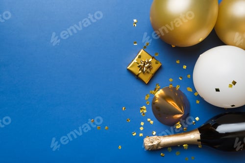 Preview: Flat lay composition of Champagne bottle gift box ribbons and confetti