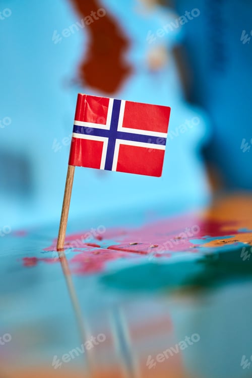 Preview: Closeup of a flag of Norway with a small stick on the map