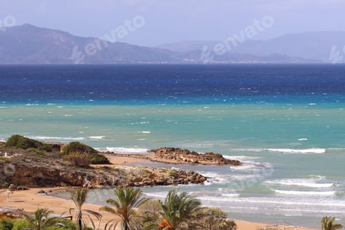 Preview: Picturesque tropical beach with bright blue water and lush green palm trees.