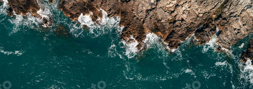 Preview: Top view of the sea waves hitting the rocks.