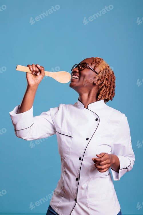 Preview: African american woman chef happily posing with ladle
