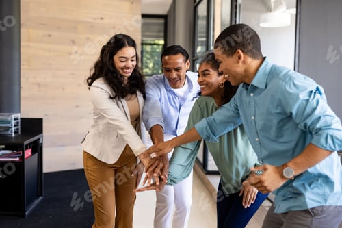 Preview: Diverse business team celebrating success with group high-five in modern office