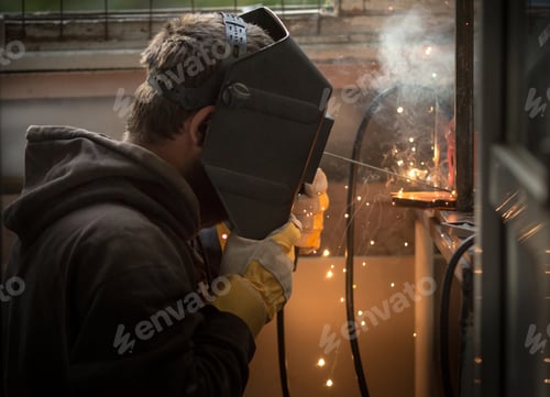 Preview: a man with a welding machine welds a metal structure, sparks fly.