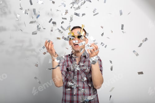 Preview: funny guy in glasses dancing in confetti on white background