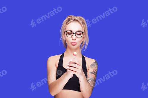 Preview: Blonde Woman Holding Lollipop Against Blue Background