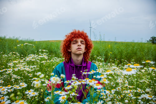 Preview: young guy with red curly hair in 80s sports suit on chamomile meadow