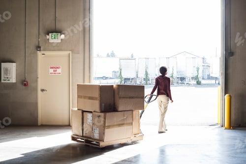 Preview: A female warehouse worker moving products with a pallet jack, to a loading door
