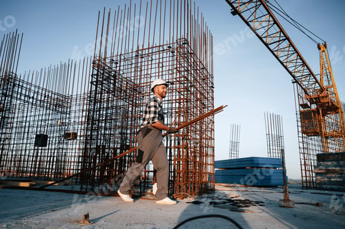 Preview: Near big metal objects. Man is working on the construction site at daytime