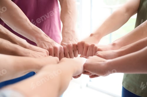 Preview: People putting fists together indoors. Unity concept