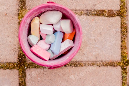 Preview: A bucket of colorful chalk on the asphalt in plastic box. Drawing with chalk on the pavement